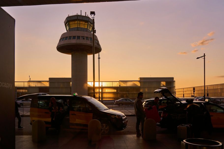 Our Taxis at London Airport Silhouette of an airport control tower at sunset with taxis nearby.