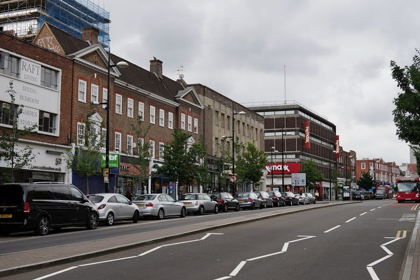 Taxi Service in Bromley, BR1–BR8 Street view featuring shops and parked cars along a side road under a cloudy sky.
