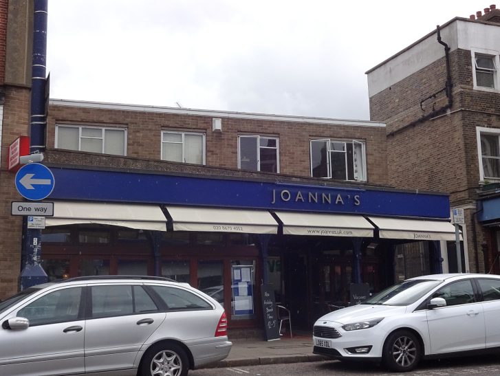 Taxi Service in Crystal Palace, SE19 A street view of a shop with blue signage and parked cars in front.