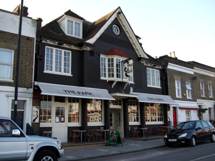 Taxi Service in West Norwood, SE27 Black and white building with a pub signage and outdoor seating area.