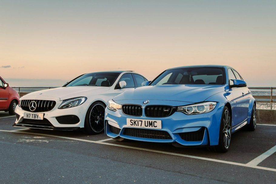 24/7 Taxis For Airport Transfer Two sports cars parked side by side: a white Mercedes and a blue BMW.