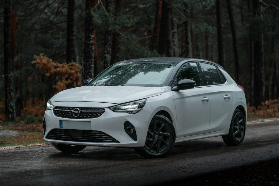 Modern Taxis for Airport Pick Up and Drop Off White hatchback car parked on a forest road surrounded by trees.