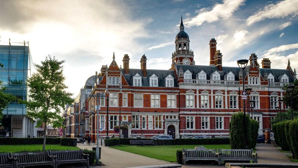 Taxi Service in Croydon Historic building with red brick and a clock tower, set against a cloudy sky.